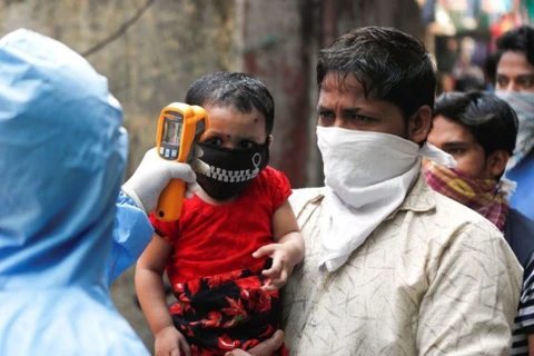 Kiểm tra thân nhiệt cho người dân khu ổ chuột ở Mumbai, Ấn Độ. (Nguồn: Reuters)
