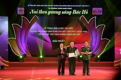 Thượng tướng Võ Trọng Việt và Thượng tướng Trần Quang Phương trao hoa và bằng chứng nhận cho tác giả đoạt giải Nhất. (Nguồn: qdnd.vn)