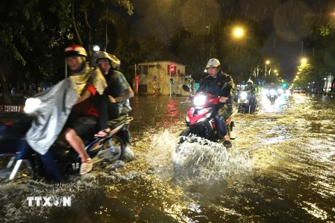 Chiều tối 10/6, mưa lớn khiến một số tuyến đường ở Hà Nội ngập úng, gây khó khăn cho người tham gia giao thông. (Ảnh: Thành Đạt/TTXVN) 