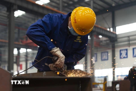Công nhân làm việc tại nhà máy ở Tương Dương, tỉnh Hồ Bắc, Trung Quốc ngày 23/3/2020 trong bối cảnh dịch COVID-19 lan rộng. (Nguồn: THX/TTXVN)
