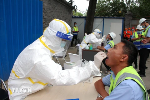 Nhân viên y tế lấy mẫu dịch xét nghiệm COVID-19 cho người dân tại Bắc Kinh, Trung Quốc ngày 17/6/2020. (Nguồn: THX/TTXVN)