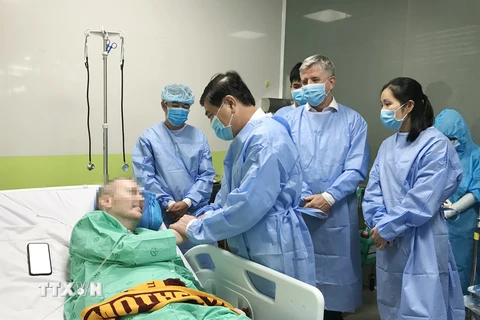 Chủ tịch Ủy ban Nhân dân Thành phố Hồ Chí Minh Nguyễn Thành Phong nói chuyện, bắt tay với bệnh nhân COVID-19 số 91. (Nguồn: TTXVN)
