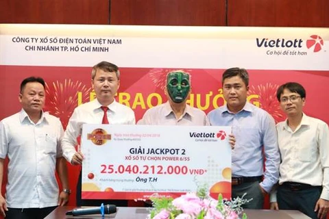Ông T.H, đeo mặt nạ, trong buổi trao thưởng tổ chức tại Thành phố Hồ Chí Minh. (Ảnh: Vietlott)