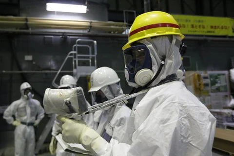 Các kỹ thuật viên đo độ phóng xạ tại các bể ngâm thanh nhiên liệu ở nhà máy Fukushima 1. (Nguồn: AFP-TTXVN) 