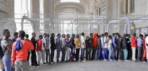 Dòng người di cư bị kẹt lại ở ga trung tâm của Milan đang chờ phát đồ ăn. (Nguồn: Huffington Post Italia)