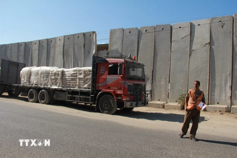 Xe tải chở vật liệu xây dựng qua cửa khẩu Kerem Shalom của Israel vào Dải Gaza. (Nguồn: THX/TTXVN)