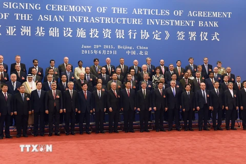 Chủ tịch Trung Quốc Tập Cận Bình (giữa, phía trước) chụp ảnh chung với các đại biểu tham dự lễ ký kết thành lập AIIB. (Nguồn: AFP/TTXVN)