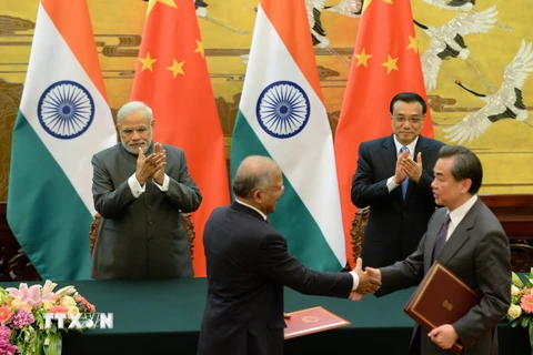 Đại diện cấp cao Trung Quốc và Ấn Độ trao đổi văn kiện hợp tác tại Bắc Kinh. (Nguồn: AFP/TTXVN)