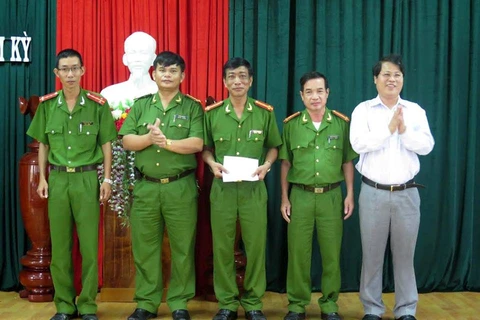 Đại diện Công an tỉnh và lãnh đạo thành phố Tam Kỳ thưởng nóng cho Công an thành phố Tam Kỳ. (Ảnh: Nguyễn Sơn/Vietnam+)