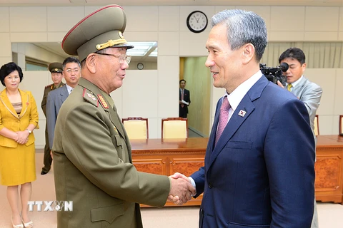 Cố vấn an ninh quốc gia Hàn Quốc Kim Kwan-jin (phải) và Chủ nhiệm Tổng cục chính trị quân đội Triều Tiên Hwang Pyong-so bắt tay nhau sau khi đàm phán kết thúc. (Nguồn: Yonhap/TTXVN)