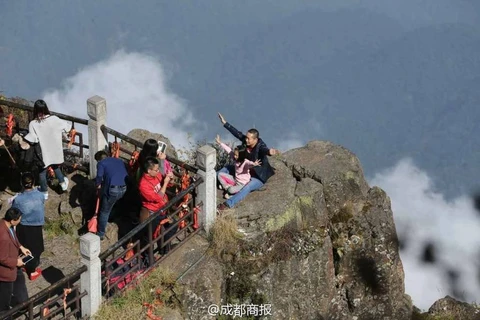 Có người còn đưa cả trẻ em ra đứng ở mỏm núi chênh vênh để có một tấm ảnh đẹp. (Nguồn: QQ News)