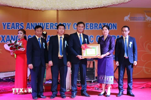 Đại diện Ngân hàng Trung ương Lào trao cho ông Lại Mạnh Quân - Tổng Giám đốc Công ty Bảo hiểm Lanexang bằng khen của Ngân hàng Trung ương Lào. (Ảnh: Phạm Kiên/TTXVN) 