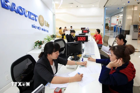 Khách hàng làm thủ tục mua bảo hiểm tại Bảo hiểm Nhân thọ chi nhánh Thành phố Hồ Chí Minh.(Ảnh: Trần Việt/TTXVN)