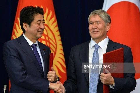 Tổng thống Kyrgyzstan Almazbek Atambayev (phải) bắt tay Thủ tướng Nhật Bản Shinzo Abe trong buổi lễ ký kết. (Nguồn: Getty)
