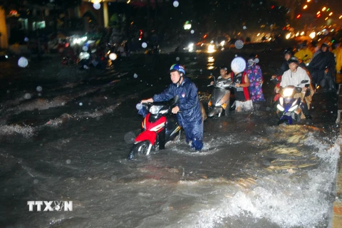 Đường Nguyễn Hữu Cảnh, phường 22, quận Bình Thạnh chìm sâu trong biển nước, hàng trăm phương tiện lưu thông bị chết máy. (Ảnh: Mạnh Linh/TTXVN)