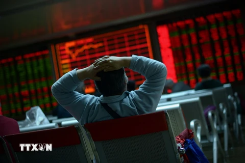 Nhà đầu tư theo dõi tỷ giá chứng khoán tại thủ đô Bắc Kinh, Trung Quốc. (Nguồn: AFP/TTXVN)