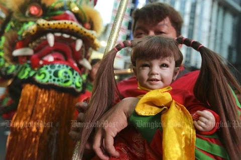 Một người dân ôm trên tay con búp bê của mình. (Nguồn: bangkokpost.com)