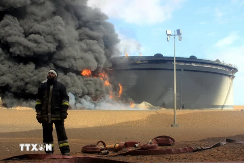 Khói bốc lên từ một kho dự trữ dầu tại nhà máy lọc dầu ở Ras Lanouf, Lybia sau các cuộc tấn công của IS. (Nguồn: AFP/TTXVN)
