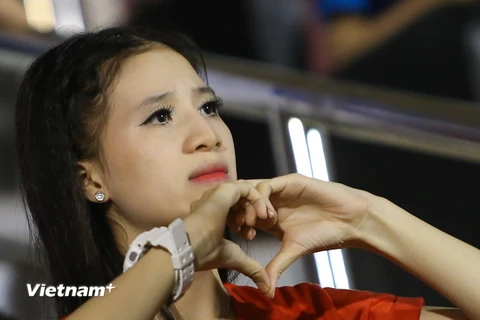 Cô gái xinh đẹp này mặc áo in hình quốc kỷ, ngồi riêng ở khu khán đài A, lặng lẽ theo dõi và không bỏ lỡ một pha bóng nào của U21 Việt Nam. (Ảnh: Minh Chiến/Vietnam+)