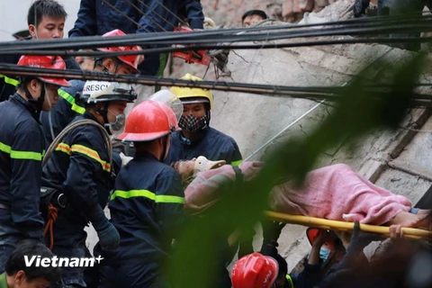 Vào hồi 8 giờ, các lực lượng chức năng vừa giải cứu được thêm một nạn nhân nữ. (Ảnh: Minh Sơn/Vietnam+)