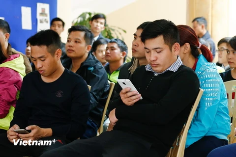 Người đàn ông này vừa ngủ gật trong lúc chờ tới lượt nộp công văn mua vé xem bán kết AFF Cup 2016 Việt Nam - Indonesia. (Ảnh: Minh Chiến/Vietnam+)
