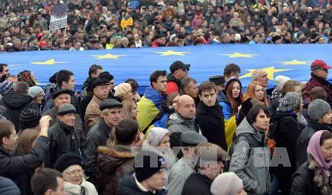 Những người biểu tình giơ cao lá cờ EU khổng lồ trong cuộc biểu tình tại Kiev. (Nguồn: AFP/TTXVN)