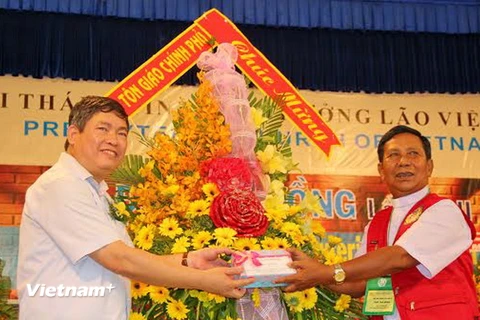 Ông Bùi Thanh Hà tặng hoa và quà chúc mừng cho đại diện Hội thánh Tin lành Trưởng lão Việt Nam. (Ảnh: Hoàng Anh Tuấn/Vietnam+)