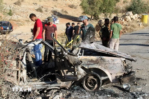Người dân địa phương và các thành viên của tổ chức Hezbollah tại hiện trường một vụ tấn công tại Liban. (Nguồn: AFP/TTXVN)