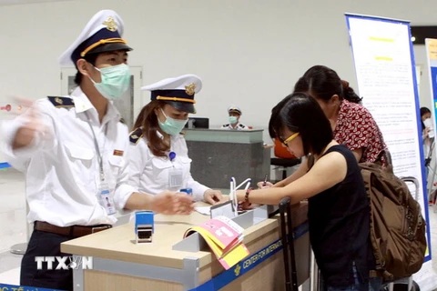 Hành khách từ Hàn Quốc nhập cảnh đến Việt Nam thực hiện kê khai tờ khai y tế. (Ảnh: Dương Ngọc/TTXVN)