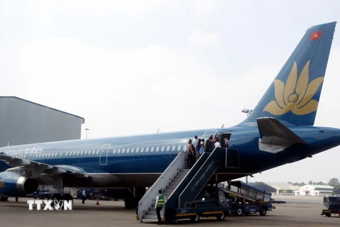 Hành khách lên máy bay của VNA tại sân bay quốc tế Tân Sơn Nhất. (Ảnh: Hoàng Hải/TTXVN)