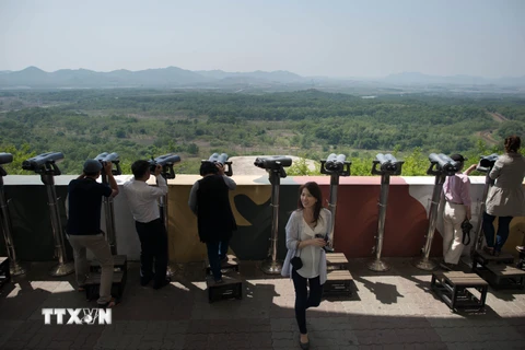 Khách du lịch ngắm phong cảnh qua đài quan sát gần khu phi quân sự Panmunjom giữa Hàn Quốc và Triều Tiên ngày 14/5. (Nguồn: AFP/TTXVN)