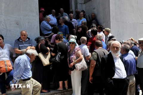 Người dân xếp hàng chờ rút tiền bên ngoài chi nhánh Ngân hàng quốc gia Hy Lạp đã đóng cửa ở Thessaloniki ngày 29/6. (Nguồn: AFP/TTXVN)