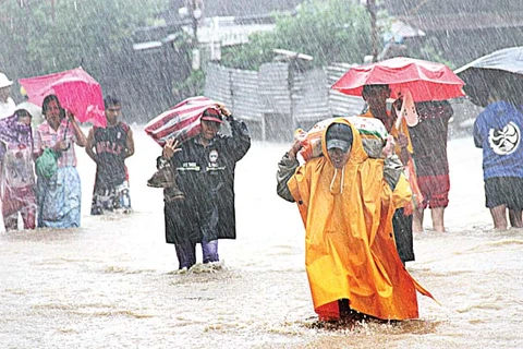 Người dân đi trong cơn mưa do bão Egay gây ra. (Nguồn: mb.com.ph)