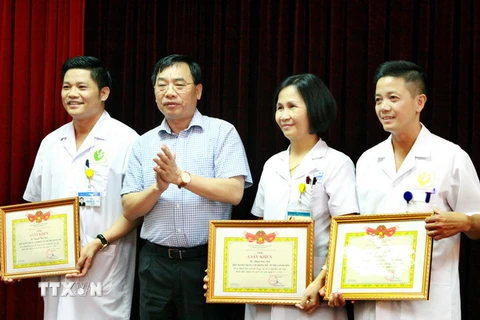 Ông Nguyễn Khắc Hiền, Giám đốc Sở Y tế Hà Nội trao tặng Giấy khen cho Ban lãnh đạo Bệnh viện Phụ sản Hà Nội. (Ảnh: Dương Ngọc/TTXVN)