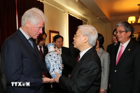 Tổng Bí thư Nguyễn Phú Trọng tặng quà lưu niệm cho Cựu Tổng thống Hoa Kỳ Bill Clinton. (Ảnh: Trí Dũng/TTXVN)