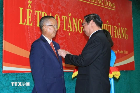 Ông Lê Hồng Anh, Ủy viên Bộ Chính trị, Thường trực Ban Bí thư gắn Huy hiệu 50 năm tuổi Đảng cho ông Trương Vĩnh Trọng. (Ảnh: Doãn Tấn/TTXVN)