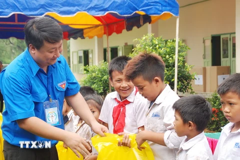 Phó Bí thư Thành đoàn Hà Nội Nguyễn Khánh Bình trao tặng dụng cụ học tập cho học sinh huyện Xaythani. (Ảnh: Phạm Kiên/TTXVN)