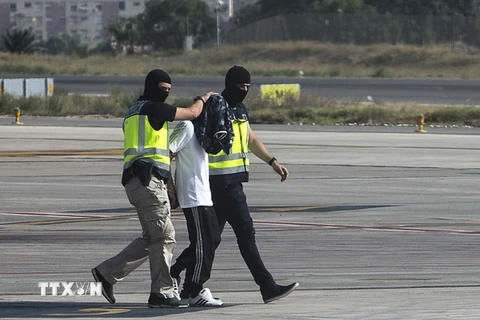 Cảnh sát Tây Ban Nha áp giải đối tượng vừa bị bắt giữ với cáo buộc tuyên truyền và tuyển mộ thành viên cho tổ chức IS tại sân bay ở Melilla ngày 22/7. (Nguồn: AFP/TTXVN)