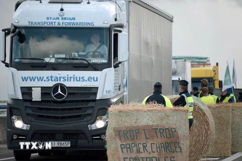Cảnh sát giải tỏa những chướng ngại vật nông dân phong tỏa trên cây cầu nối Pháp và Đức ở Strabourg, miền đông nước Pháp trong cuộc biểu tình ngày 27/7. (Nguồn: AFP/TTXVN)