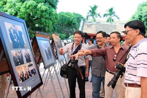 Các nhiếp ảnh gia và du khách xem triển lãm “Quan hệ Việt-Mỹ và nước Mỹ qua ống kính nhà nhiếp ảnh Việt Nam”. (Ảnh: An Đăng/TTXVN)