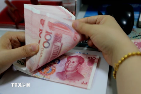 Kiểm tiền giấy mệnh giá 100NDT tại ngân hàng ở Liên vận cảng, tỉnh Giang Tô, Trung Quốc. (Nguồn: AFP/TTXVN)