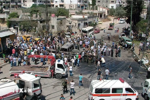 Lực lượng chức năng làm nhiệm vụ tại hiện trường vụ đánh bom xe ở Latakia. (Nguồn: AFP/TTXVN)