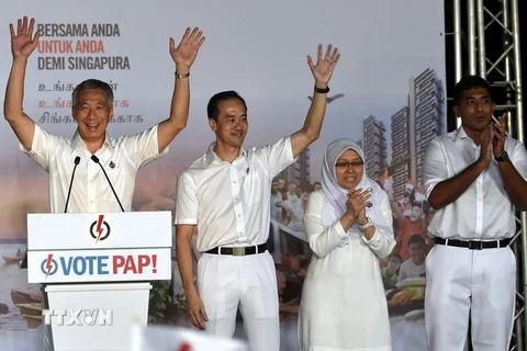 Thủ tướng Singapore Lý Hiển Long (trái) và các thành viên đảng PAP trước những người ủng hộ sau khi kết quả bầu cử được công bố ngày 12/9. (Nguồn: AFP/TTXVN)