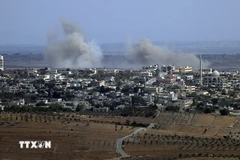 Khói bốc lên từ làng Jubata al-Khashab của Syria sau một vụ không kích của trực thăng quân sự ngày 13/10. (Nguồn: AFP/TTXVN)