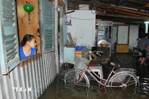 Triều cường dâng cao gây ngập nước trong nhà nhiều hộ dân tại các con hẻm trên đường Xô Viết Nghệ Tĩnh, phường 25, quận Bình Thạnh. (Ảnh: Mạnh Linh/TTXVN)