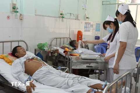 Các bác sỹ Bệnh viện Đa khoa Nguyễn Đình Chiểu thăm khám và điều trị cho bệnh nhân tại Khoa Tim mạch . (Ảnh: Phương Vy/TTXVN)