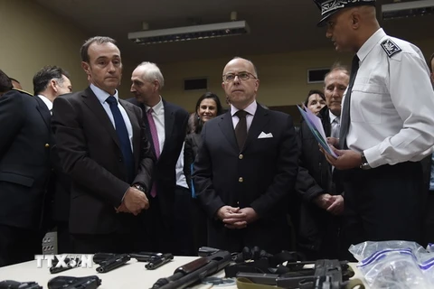 Bộ trưởng Nội vụ Pháp Bernard Cazeneuve (giữa) kiểm tra số vũ khí đạn dược do cảnh sát thu giữ được trong chiến dịch truy quét khủng bố tại Nanterre ngày 13/11. (Nguồn: AFP/TTXVN)