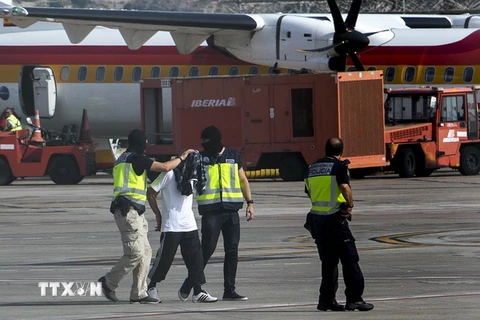 Cảnh sát Tây Ban Nha áp giải một đối tượng vừa bị bắt giữ tại sân bay ở Melilla ngày 22/7. (Nguồn: AFP/TTXVN)