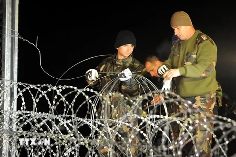 Binh sỹ Hungary đóng cửa biên giới tại Botovo bằng hàng rào dây thép gai khi những nhóm người di cư cuối cùng vượt qua biên giới từ Tovarnik, Croatia ngày 16/10. (Nguồn: Reuters/TTXVN)