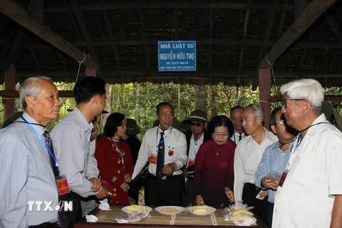 Các đại biểu thăm nhà làm việc của cố Luật sư Nguyễn Hữu Thọ, nguyên Chủ tịch Mặt trận Dân tộc Giải phóng miền Nam tại căn cứ. (Ảnh: Lê Đức Hoảnh/TTXVN)